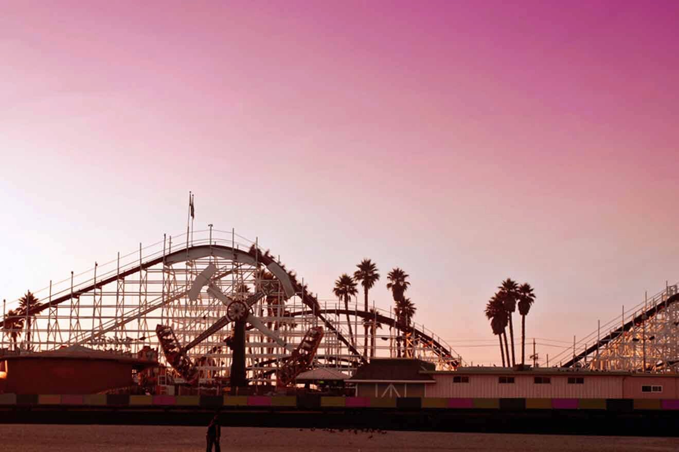 An amusement park with a roller coaster in the background.