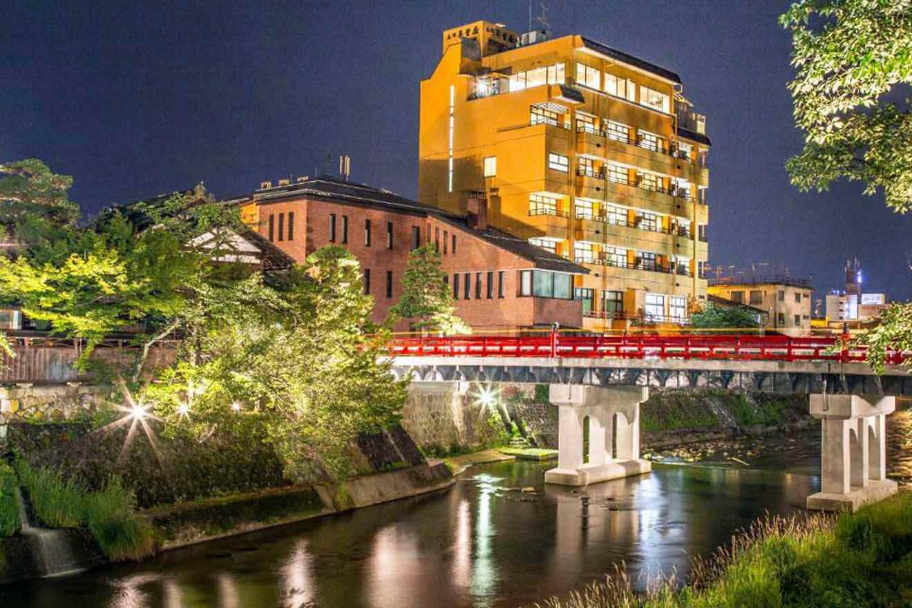 A city at night with a bridge over a river.