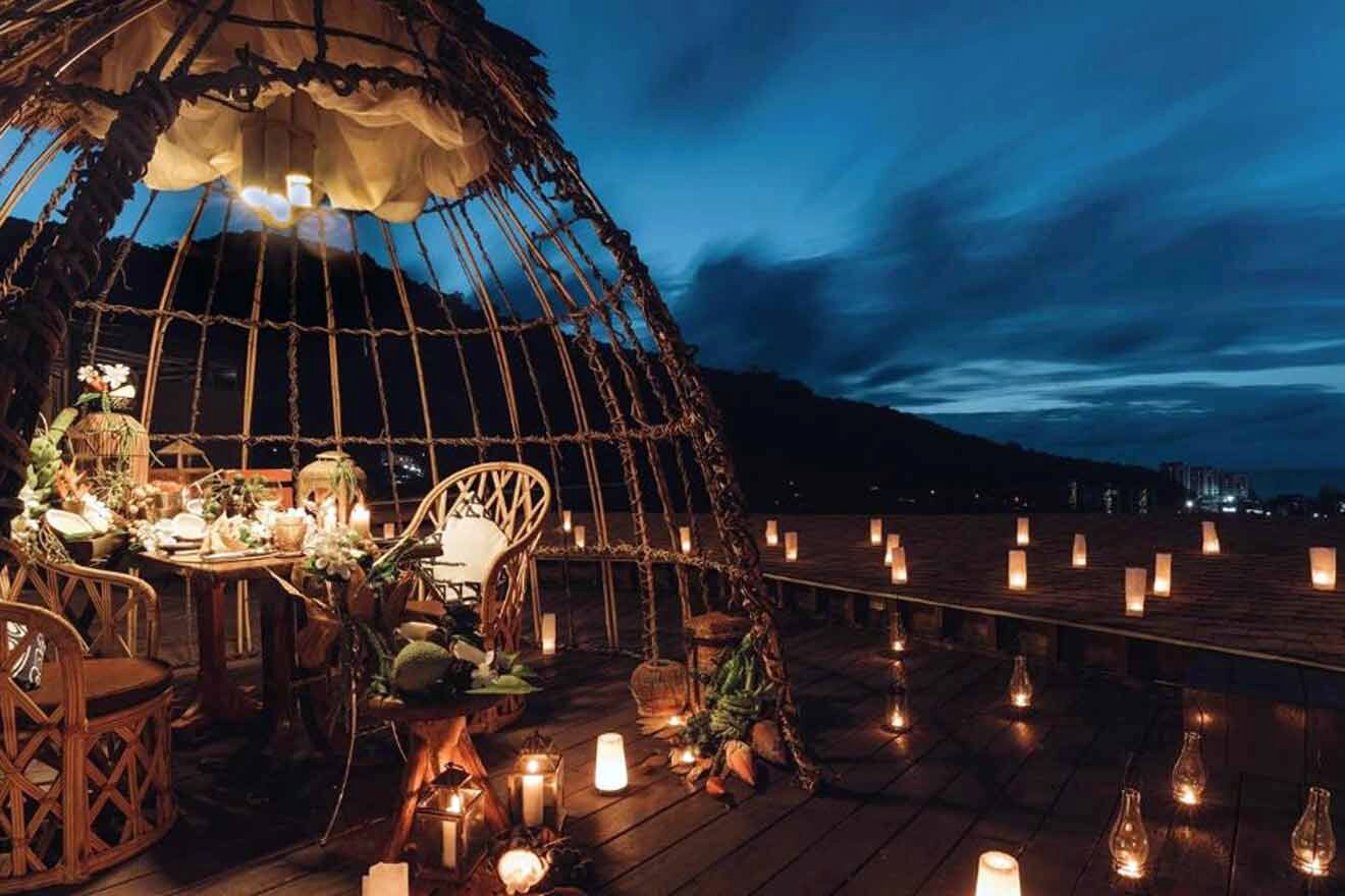 A candlelit dinner on a wooden deck at night.
