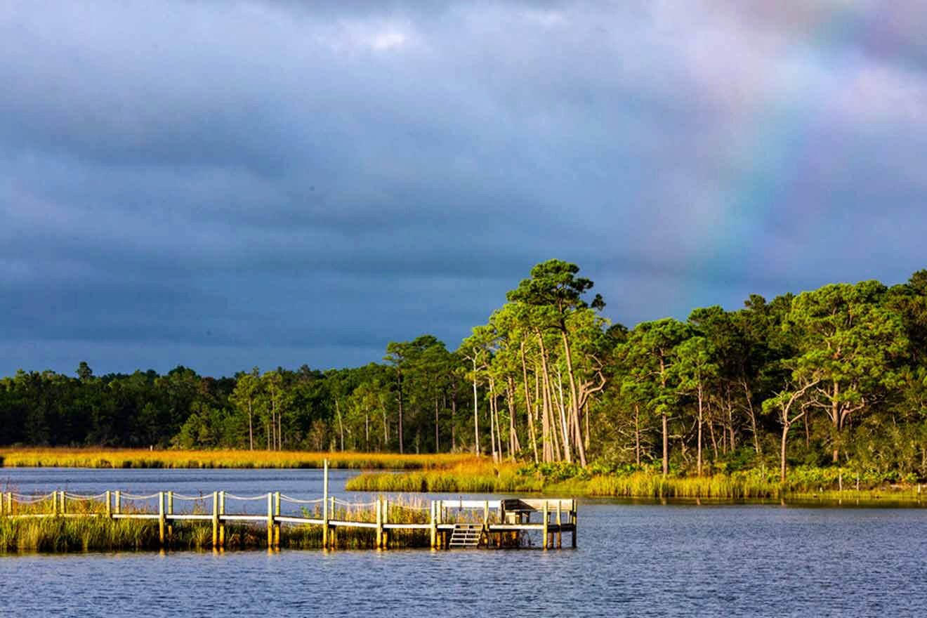 A rainbow over a lake with a dock in the background.
