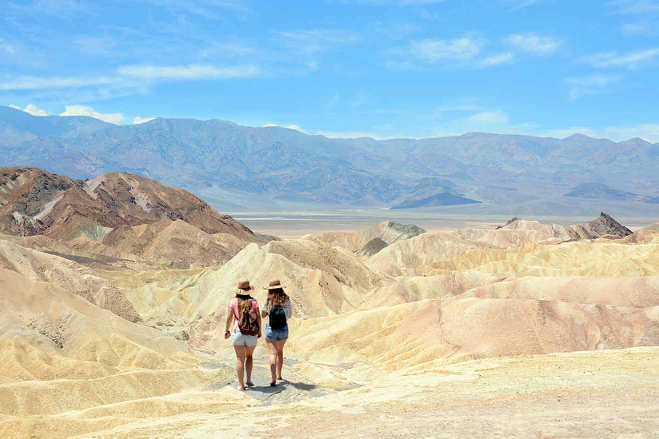 Two women standing on top of a mountain in death valley.