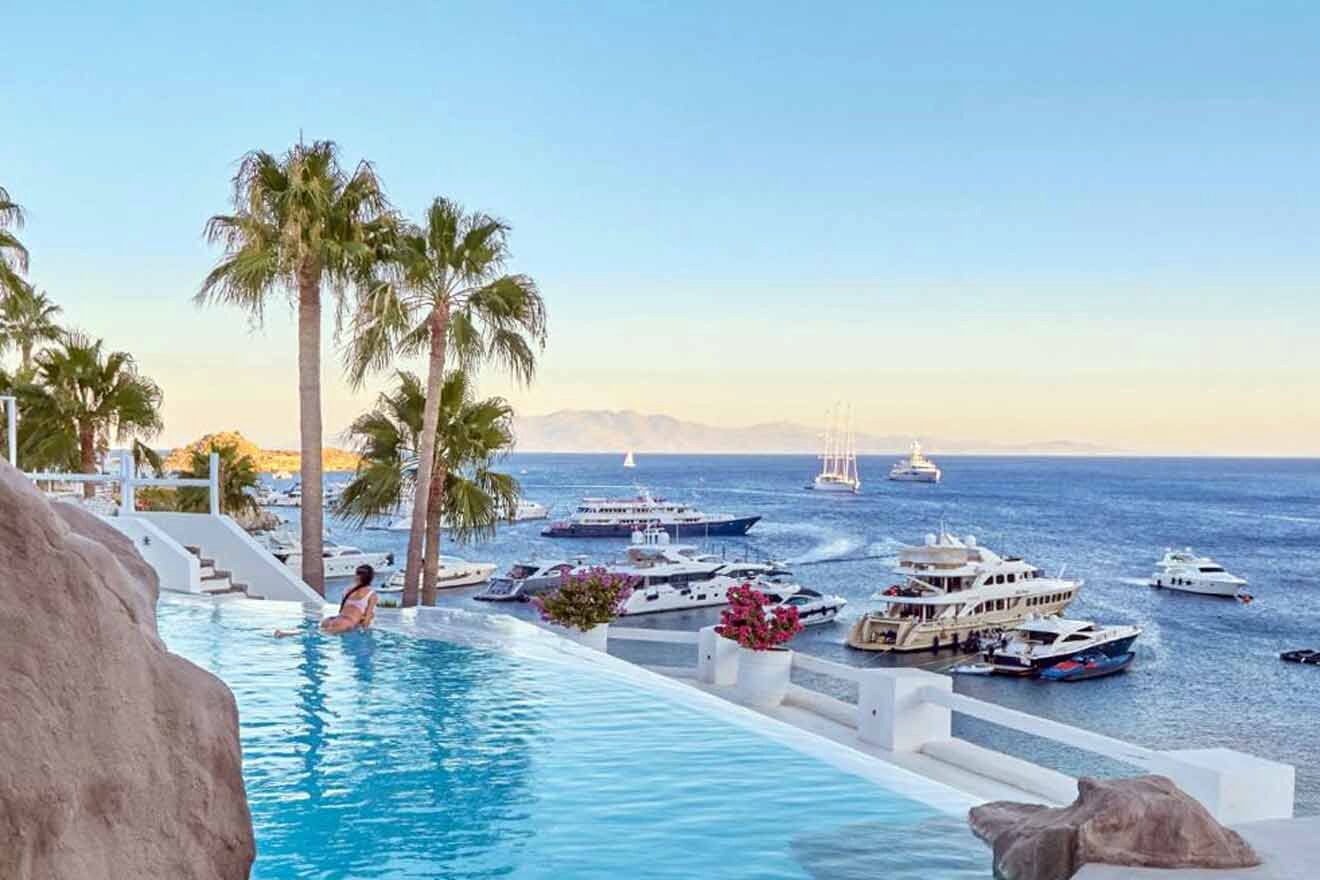 A swimming pool overlooking the ocean and boats.