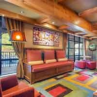 The lobby of a hotel with colorful furniture and a fireplace.