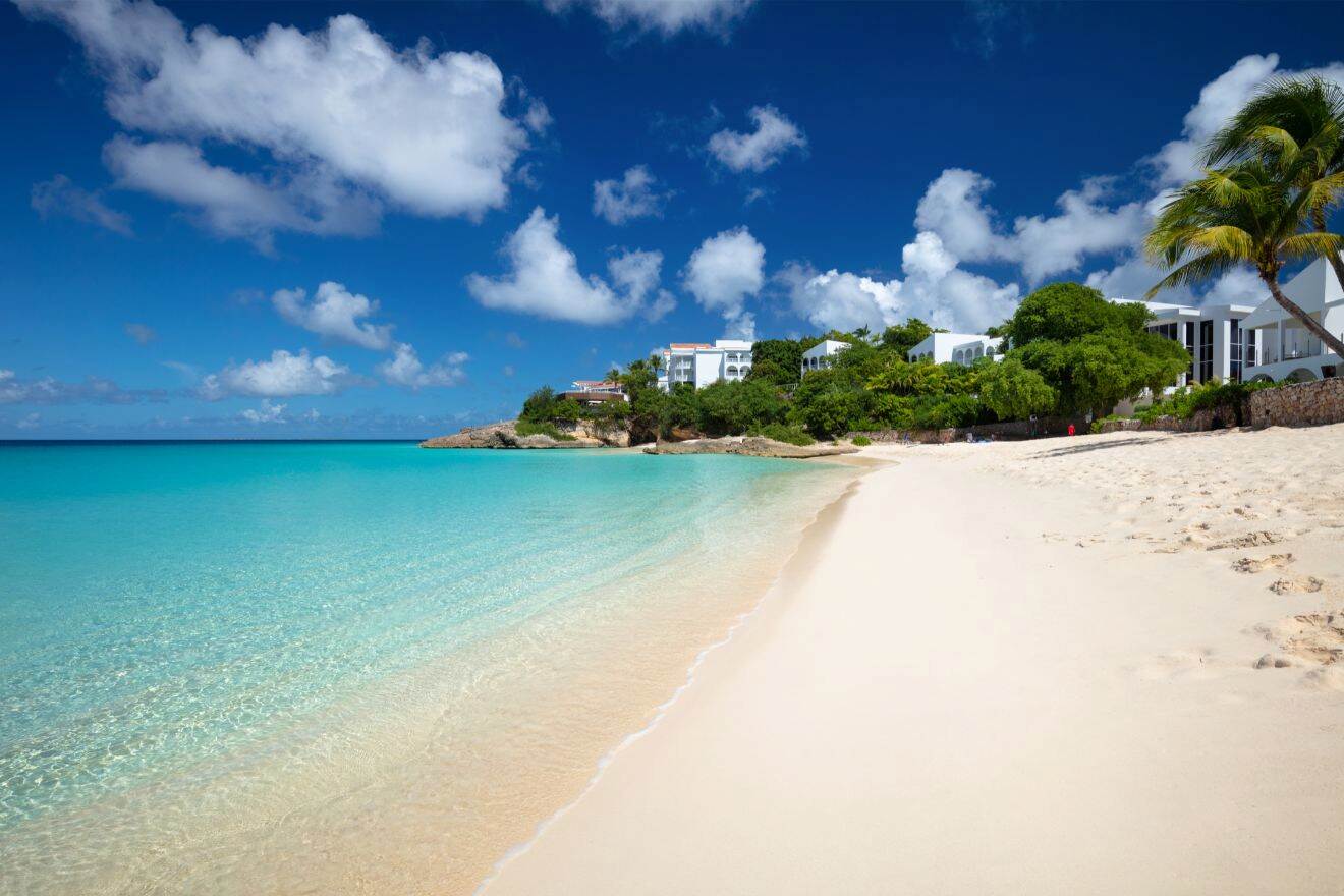 a sandy beach with a hotel at the end