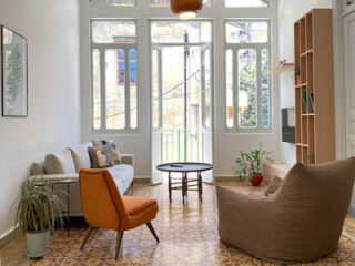 A living room with a couch, chairs and a window.