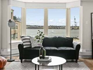 A living room with large windows overlooking the water.