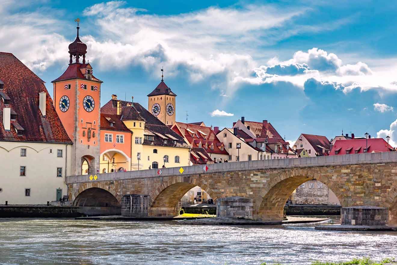 A bridge over a river with a clock tower in the background.