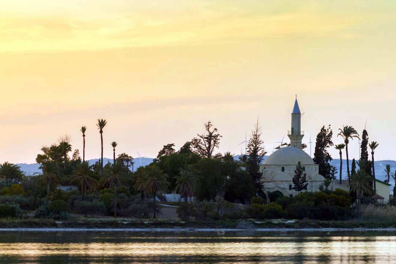 Tekke Mosque ner Larnaca sits on the shore of a body of water.
