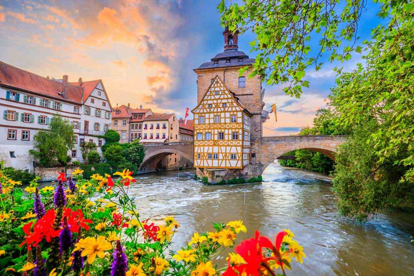 A bridge over a river with colorful flowers in the background.