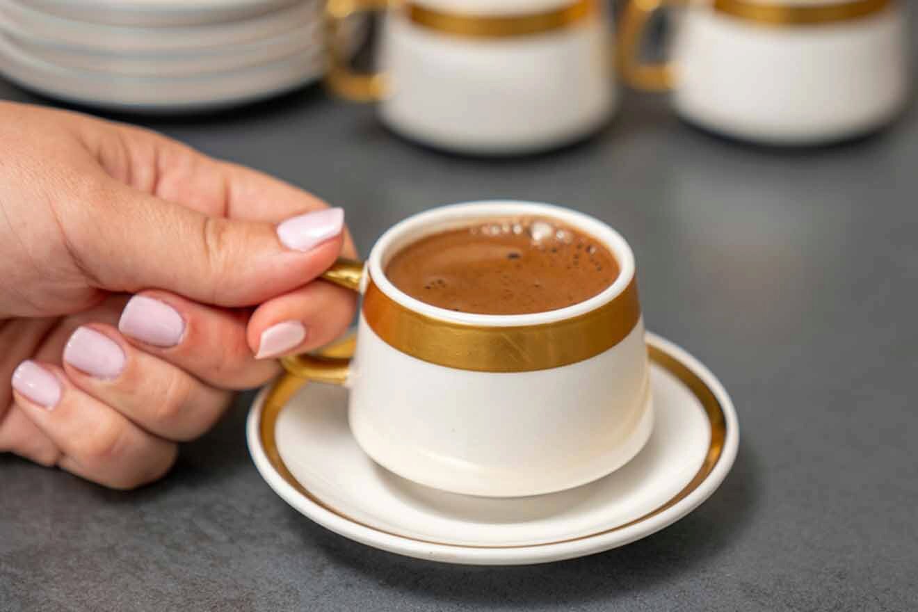 A hand holding a cup of cypriot coffee.