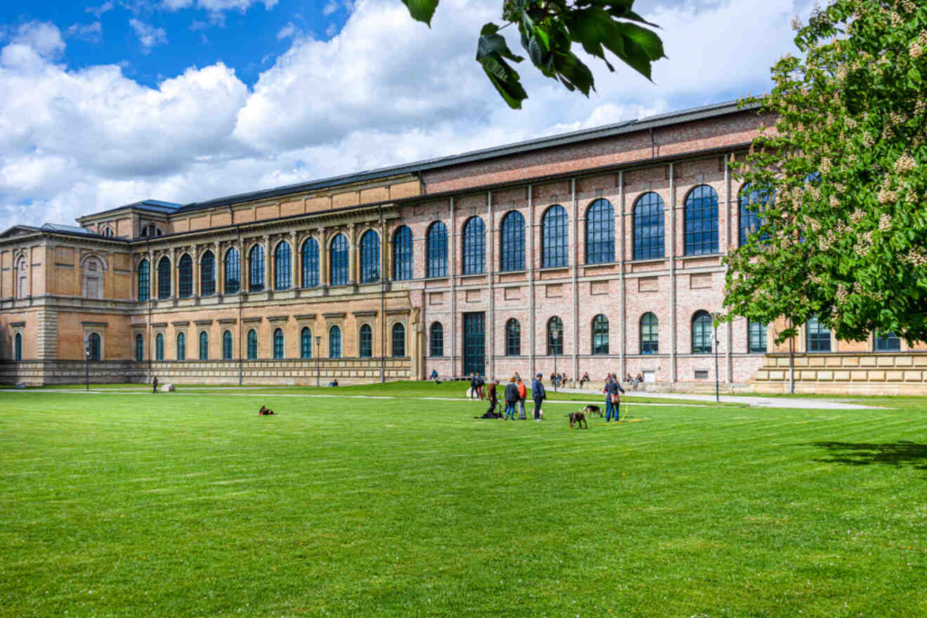 People sitting on the grass in front of a museum building