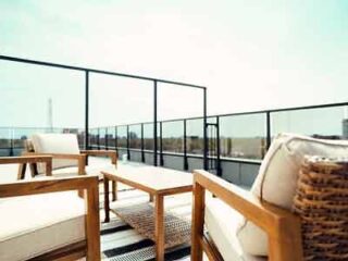 A balcony with wicker furniture and a view of the city.