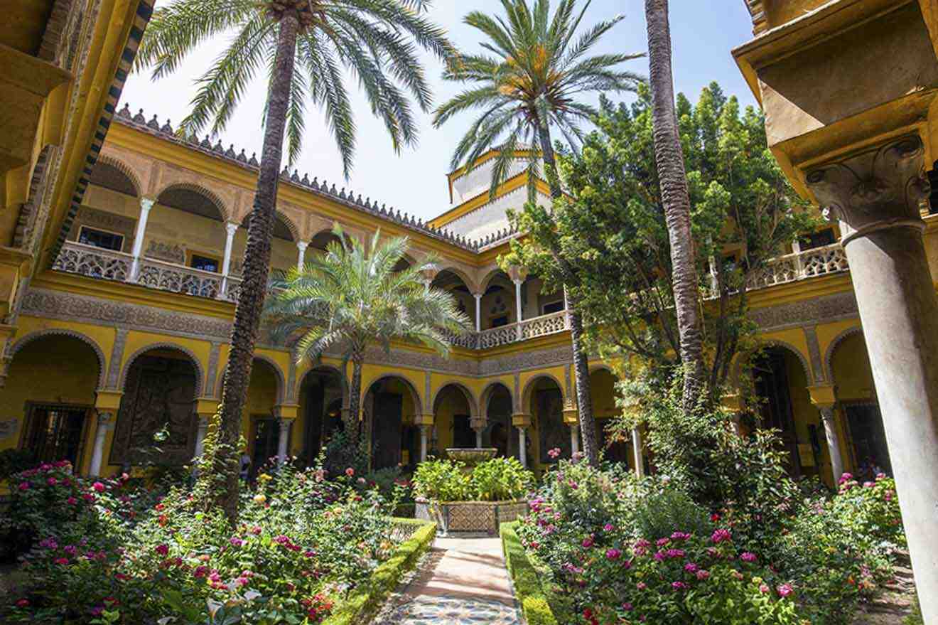 A courtyard with palm trees and flowers.