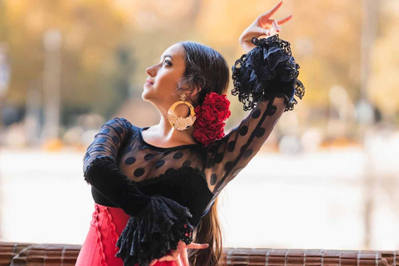 A woman in a red dress is performing flamenco.