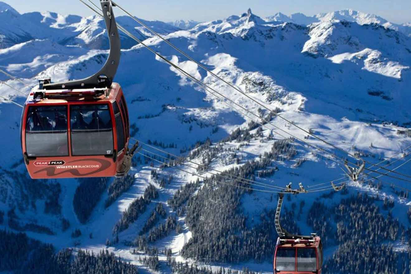 Two red gondolas flying over a snow covered mountain.
