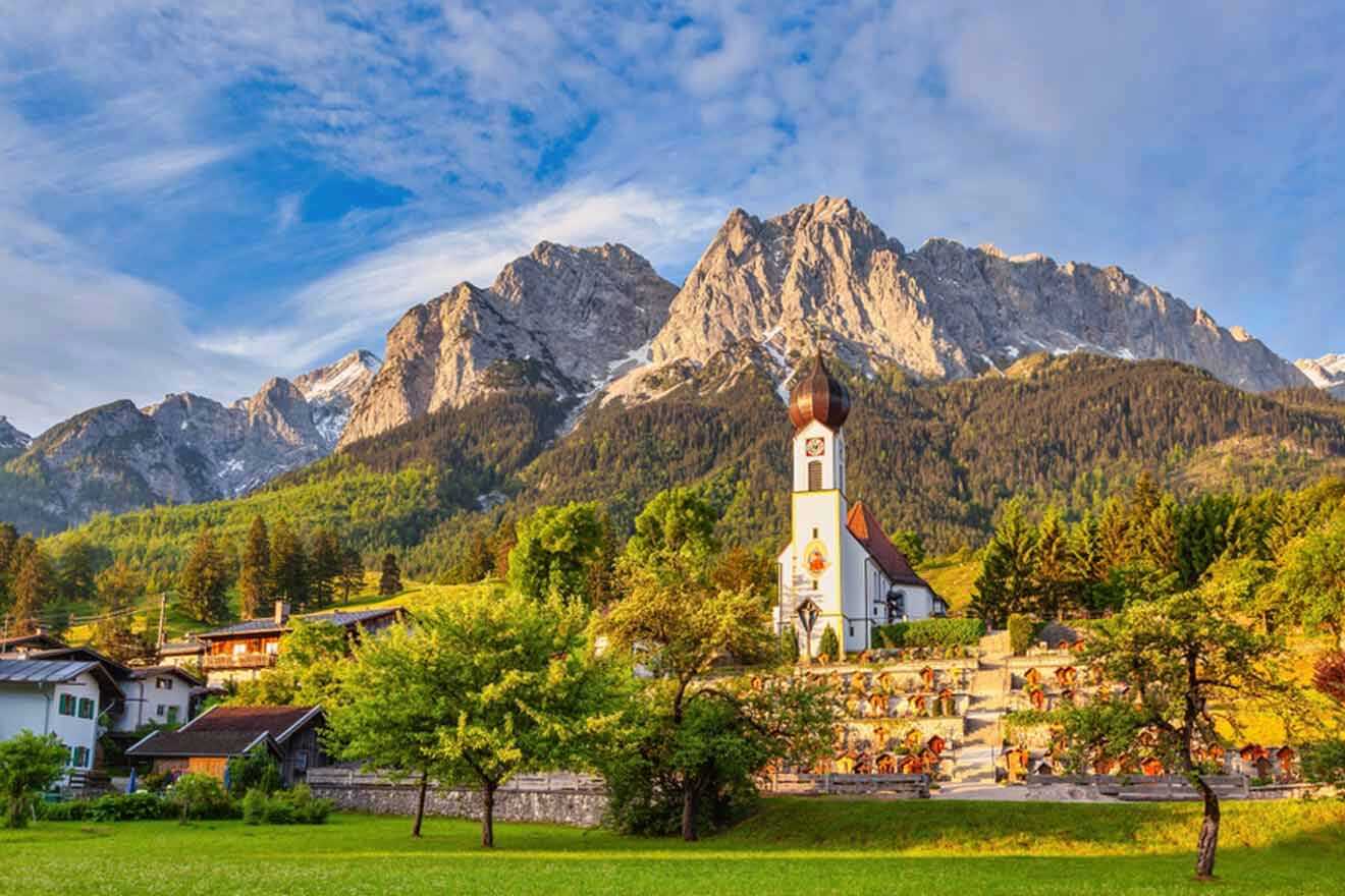 A village in the mountains with a church in the background.