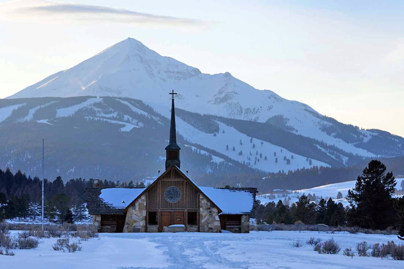 A church in the snow with a mountain in the background.