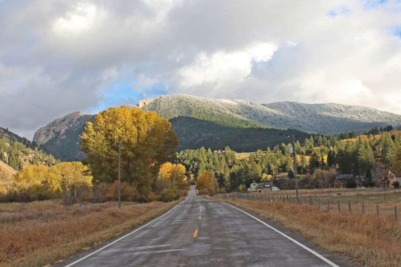 a road leading towards mountains in autumn