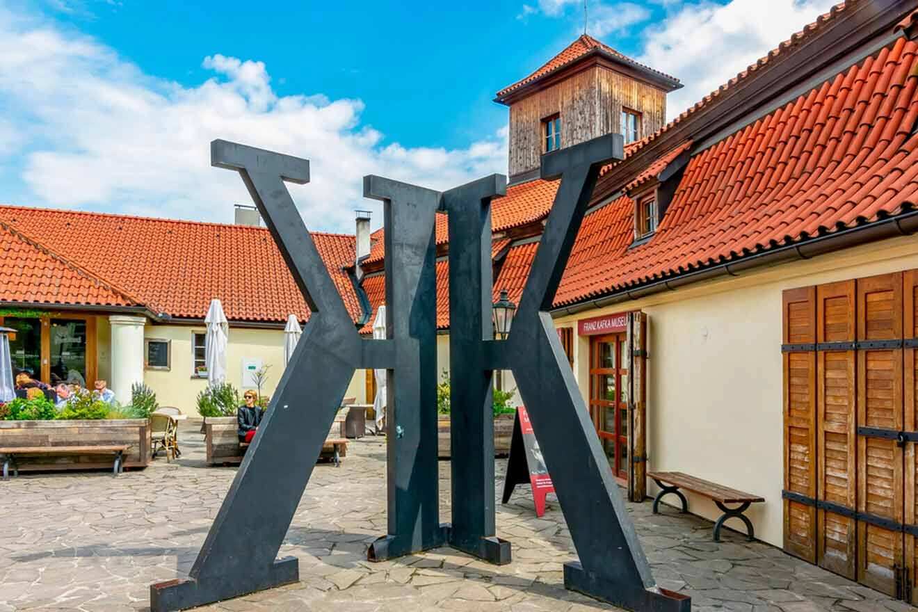 A statue of the letter k in front of a building.