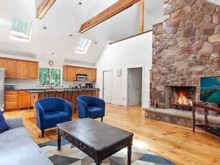 A living room with a fireplace and stone walls.