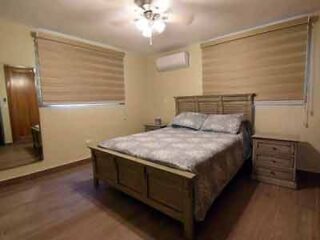 A bedroom with hardwood floors and a ceiling fan.