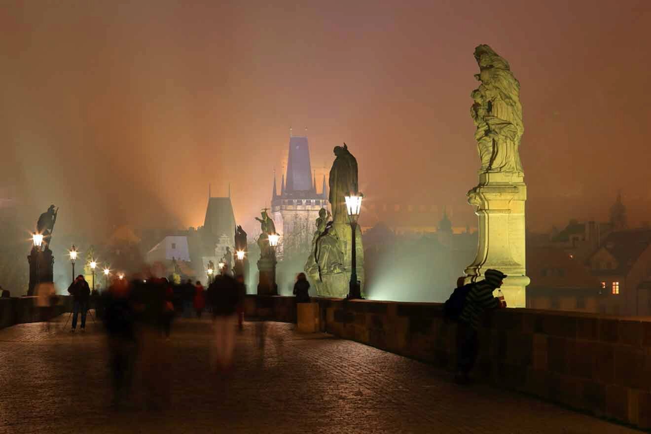 charles bridge with tall sculptures on a foggy night