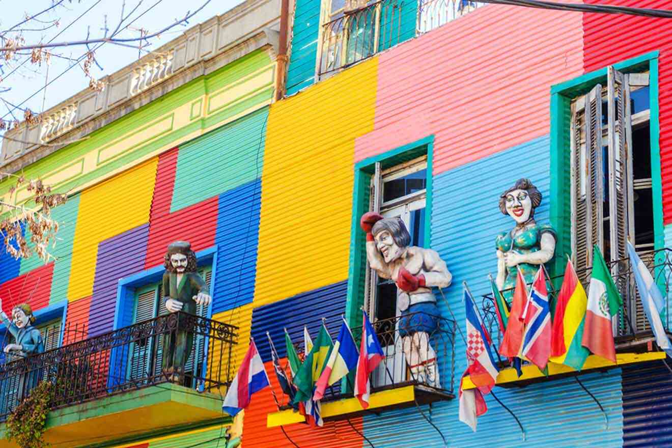 A colorful building with sculptures and flags on the balcony in La Boca in Buenos Aires.