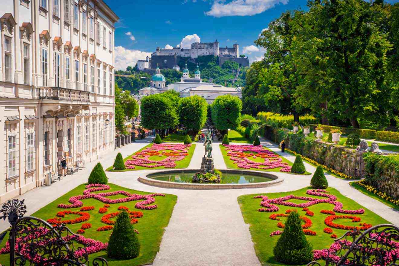 A garden with a castle in the background.