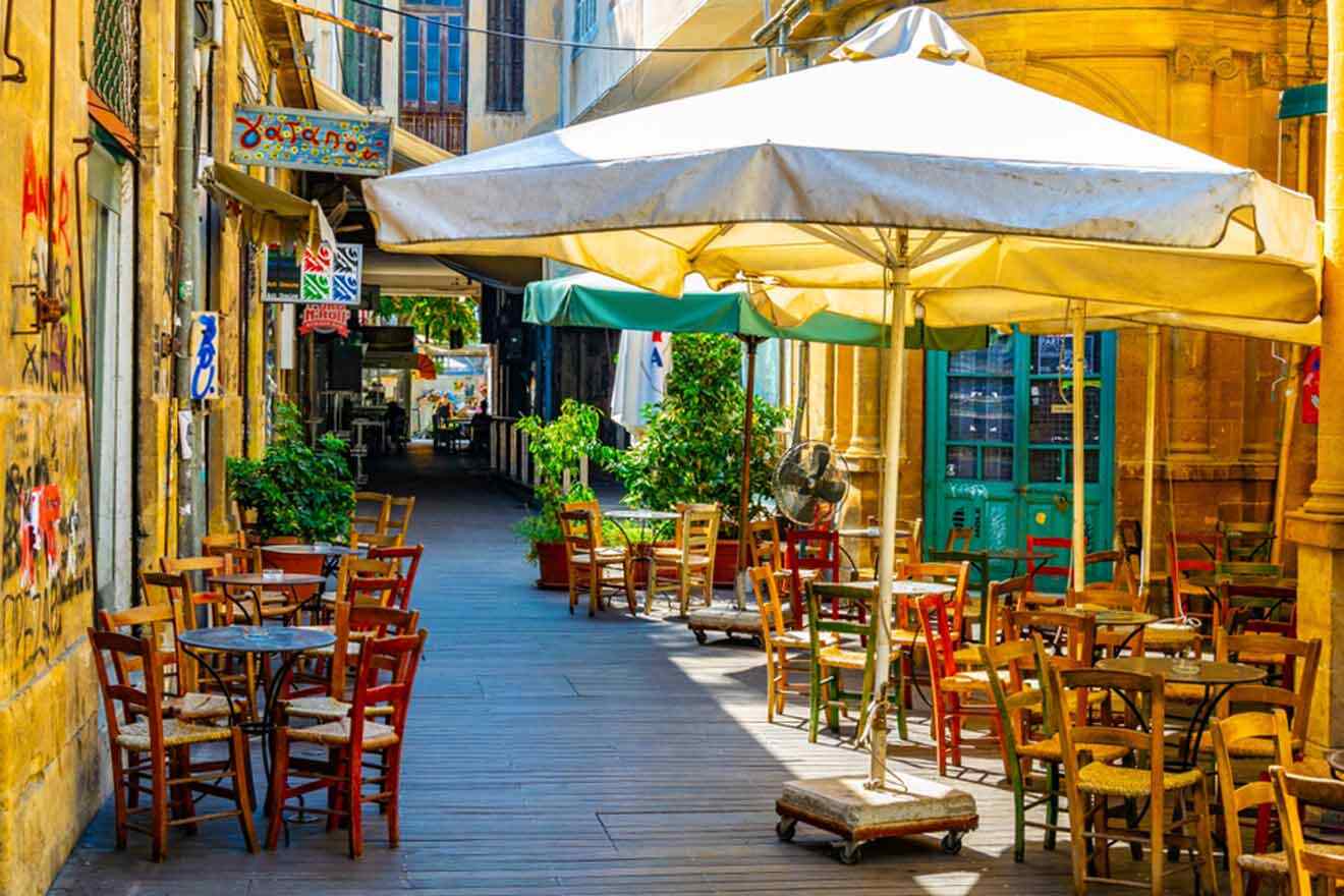 A street lined with tables and umbrellas.