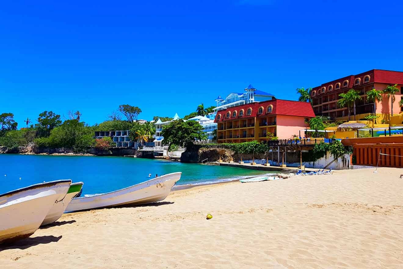 A beach with boats on the sand near some buildings