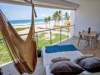 A hammock on a balcony overlooking the ocean.