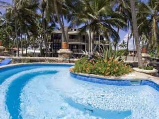 A swimming pool surrounded by palm trees.