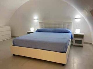 A bedroom with an arched ceiling and a bed.