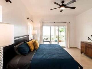 A bed in a bedroom with a ceiling fan.