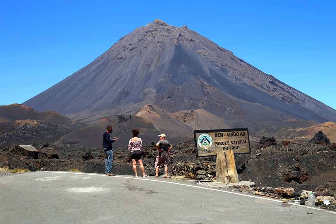 A group of people standing in front of a volcano.