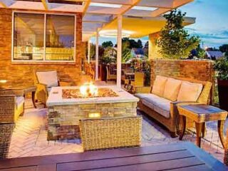A patio with wicker furniture and a fire pit.