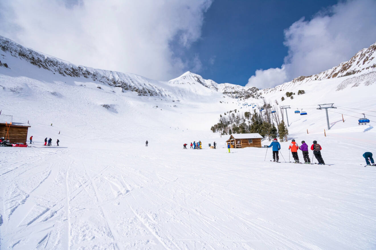 A group of skiers and snowboarders on a snowy slope.