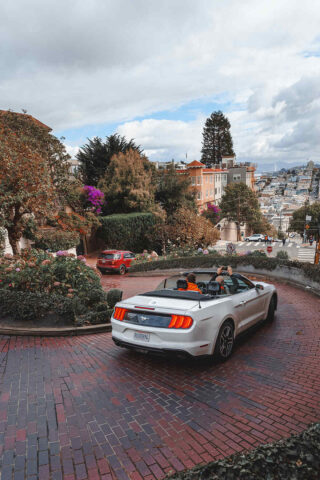 A ford mustang convertible parked on a street in san francisco.