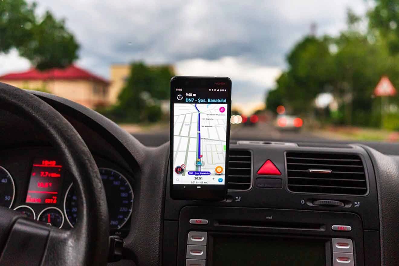 A cell phone with a gps on the dashboard of a car.