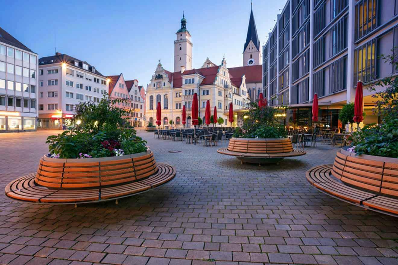 A group of wooden benches in a square in a city.
