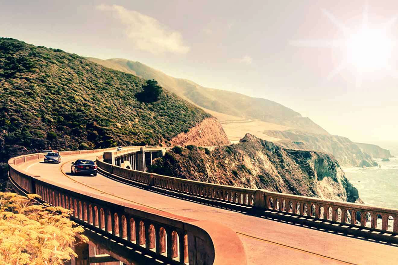 road by the ocean surrounded by hills