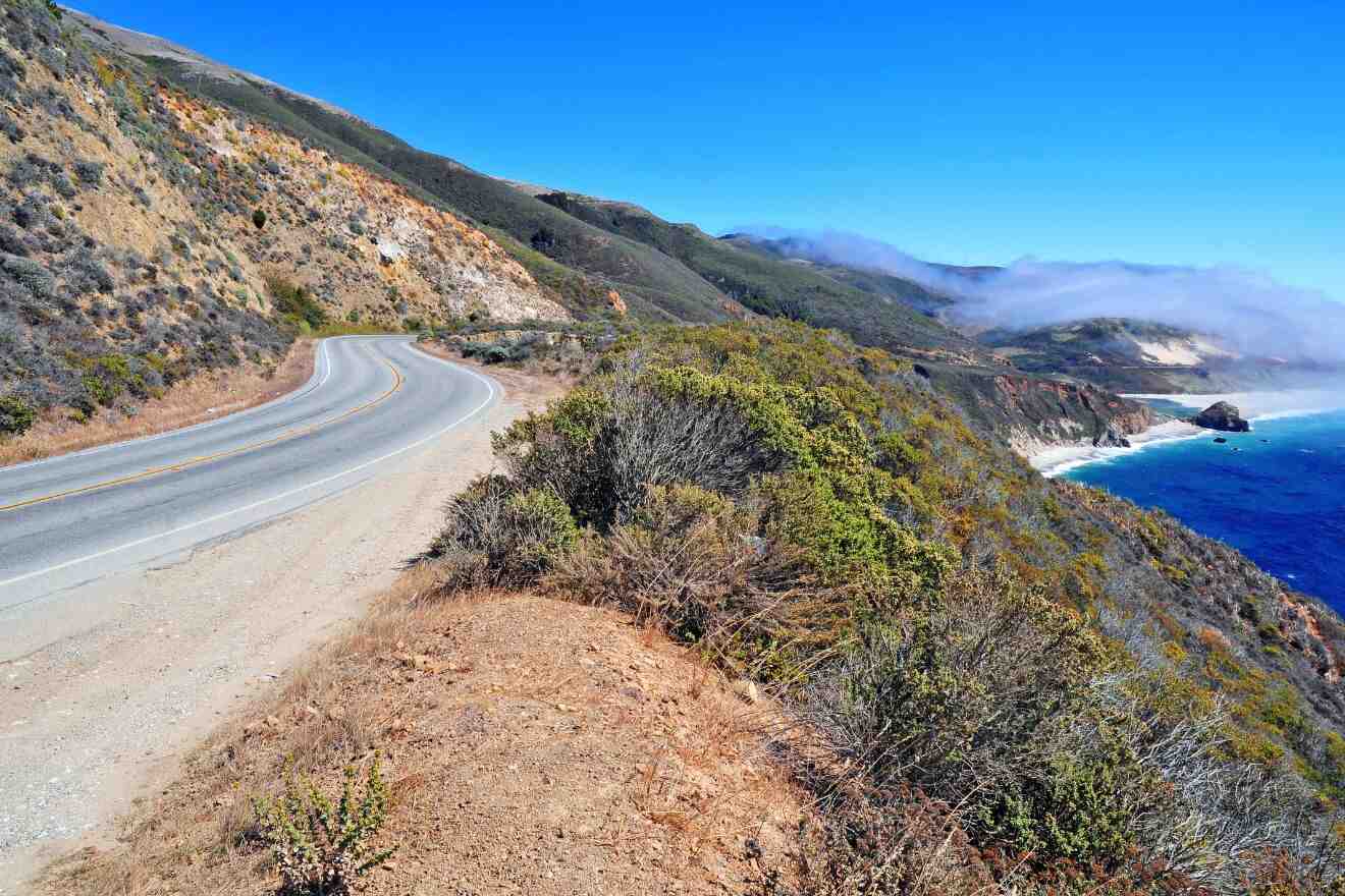 road winding round the mountain next to the ocean