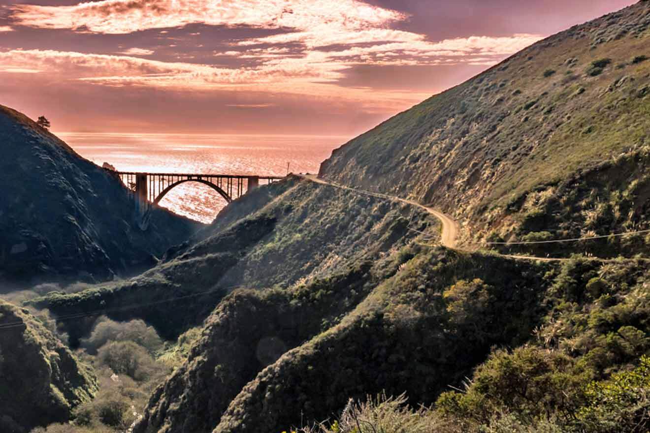 A bridge over a canyon with the ocean in the background.