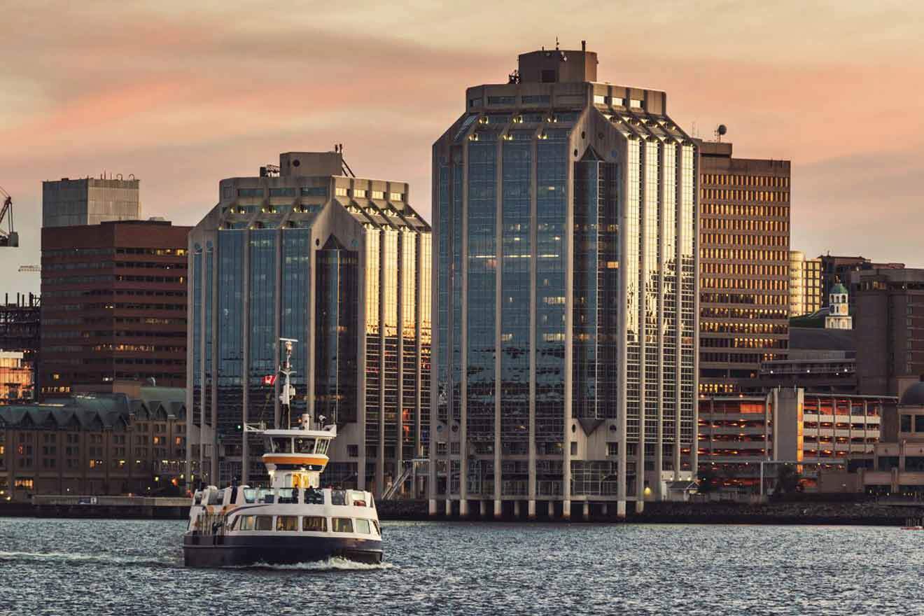 A boat in the water in front of tall buildings.