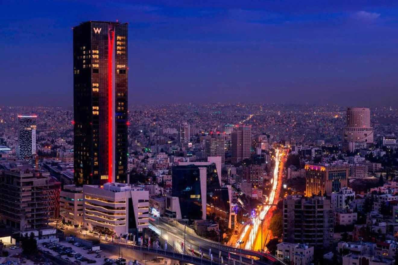 A city at night with a tall building in the background.