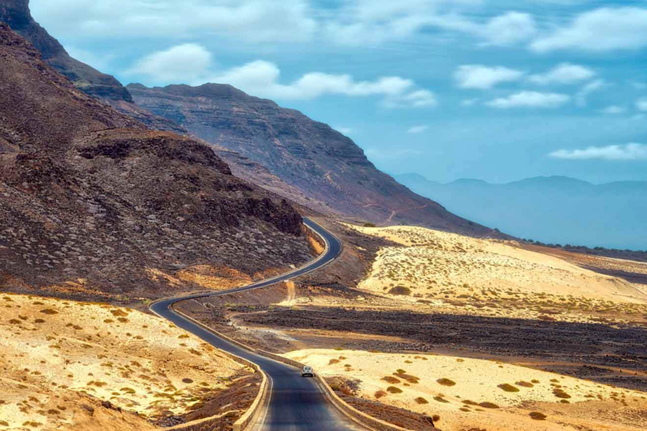 A road in the desert with mountains in the background.