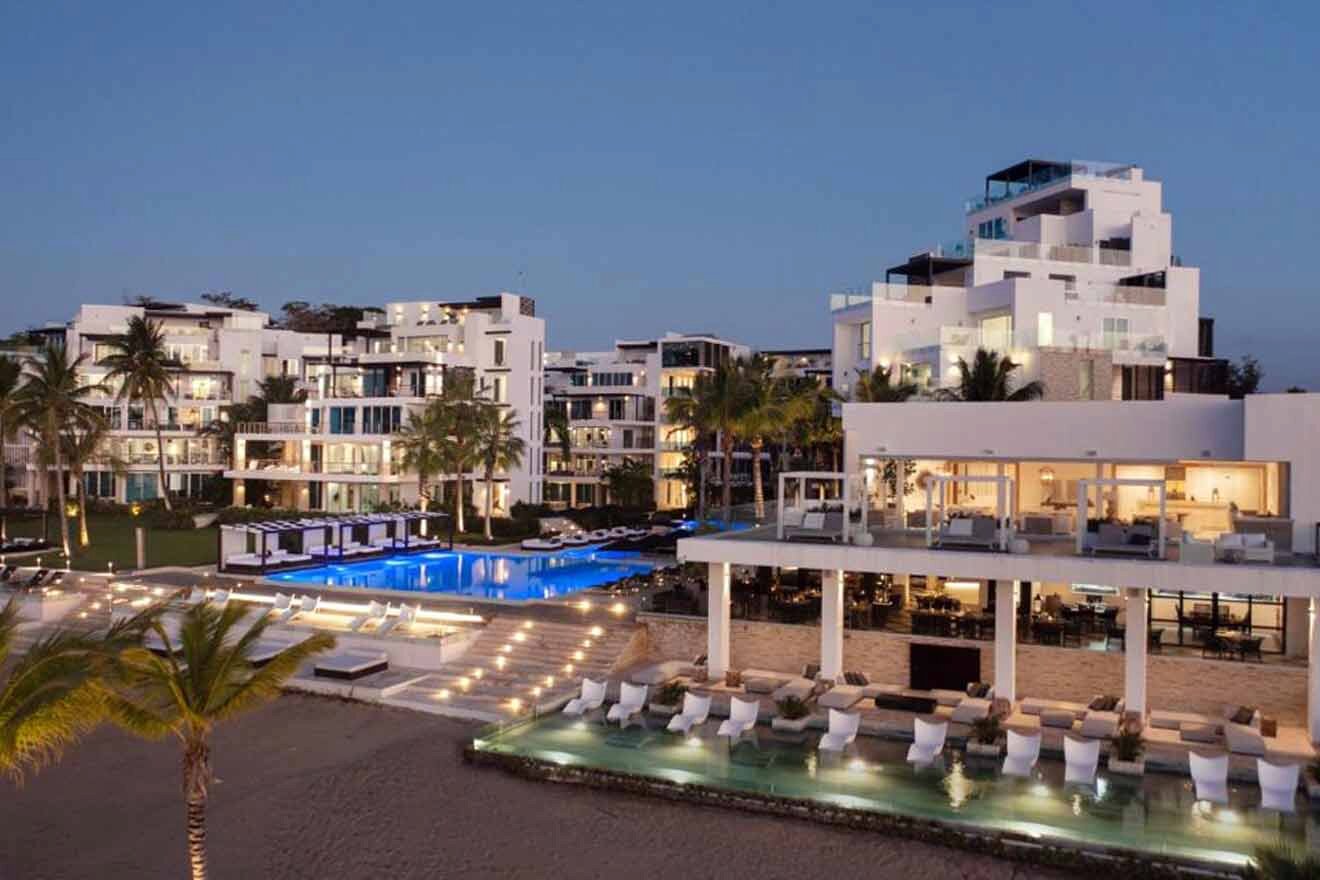 A resort at dusk with a pool and lounge chairs.