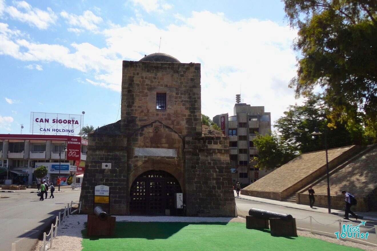 A stone gate in the middle of a city.