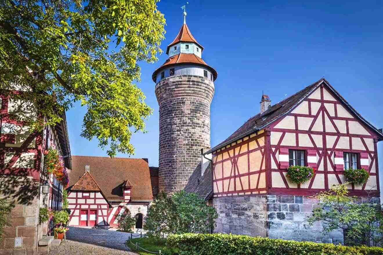 A castle with a tower in the middle of a cobbled street.