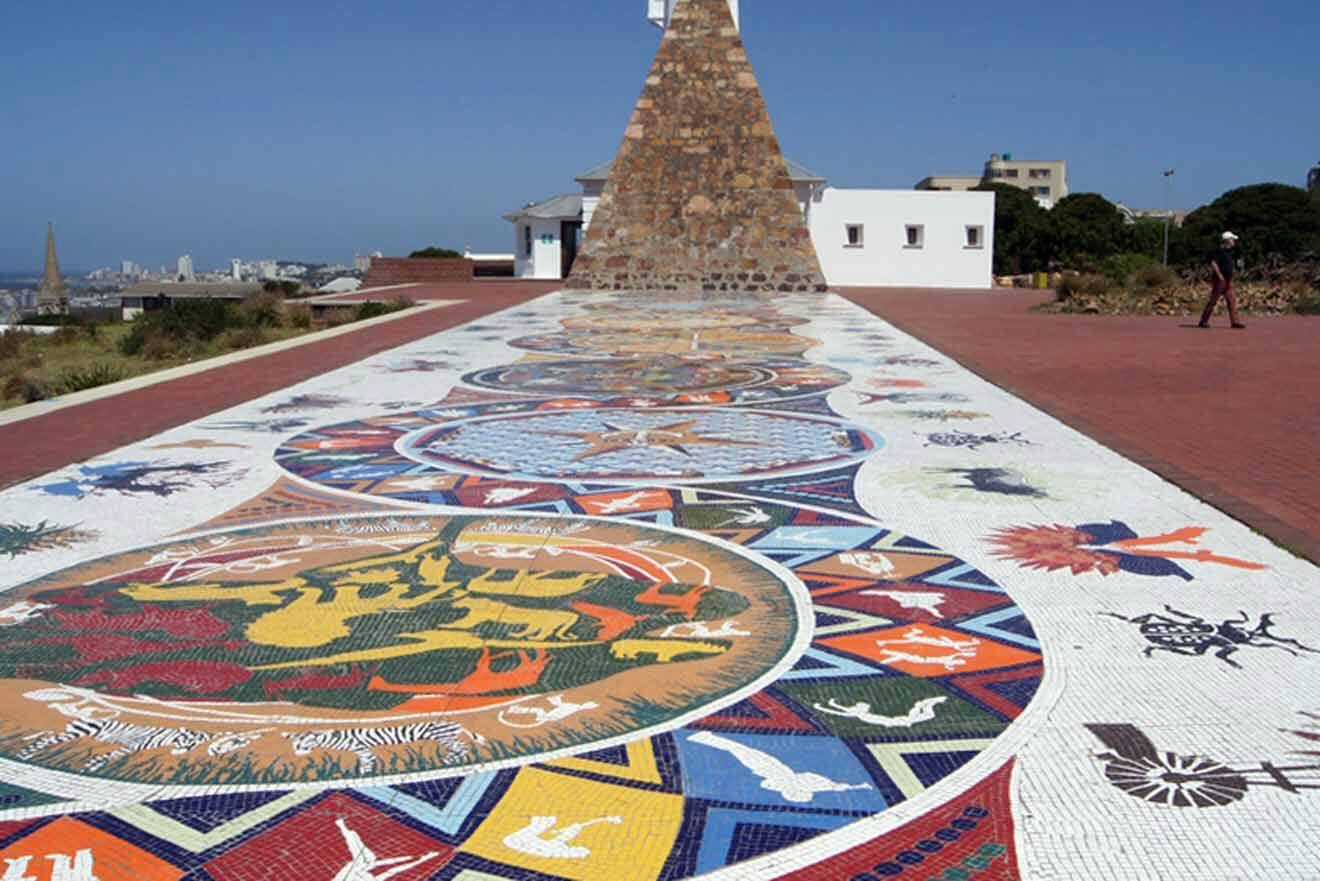 A colorful tiled walkway in front of a monument.